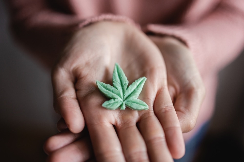 Palm holding out a marijuana shaped candy with Delta 9 THC
