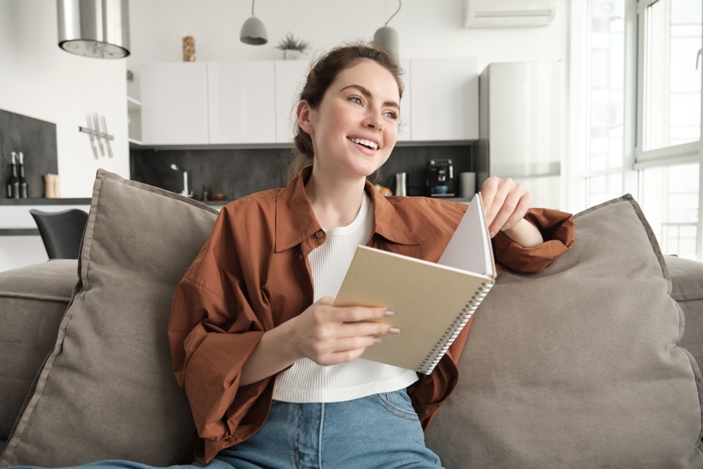 Woman reading a notebook with quotes on addiction recovery sobriety